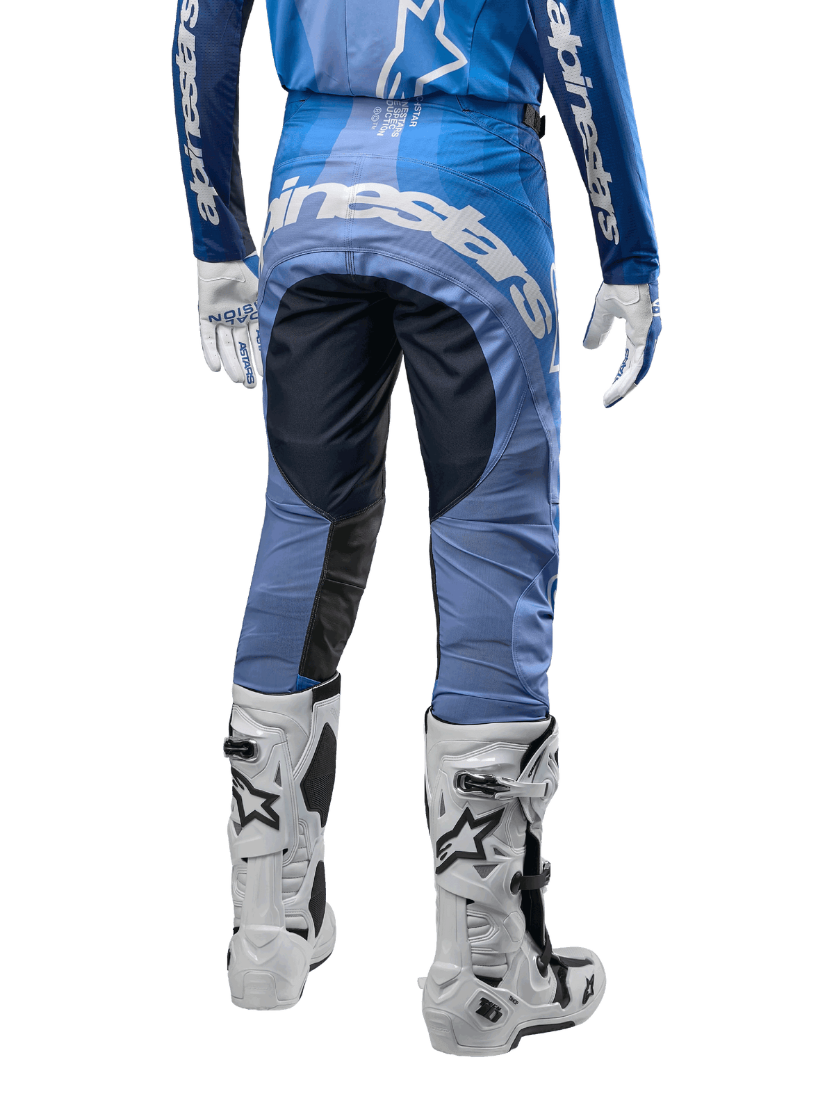 Alpinestars 2024 Techstar Pneuma crossbroek, motorcross broek, donkerblauw en lichtblauw, achteraanzicht met opvallende witte branding op het zitvlak en versterkte zwarte panelen, gecombineerd met witte Tech 10 motorcrosslaarzen