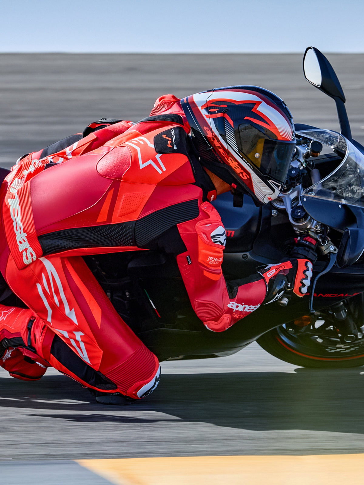 Alpinestars GP Plus V4 Sprint eendelig leren pak, rood en wit, Tech-Air ready motorracepak op rijder in een circuitbocht.