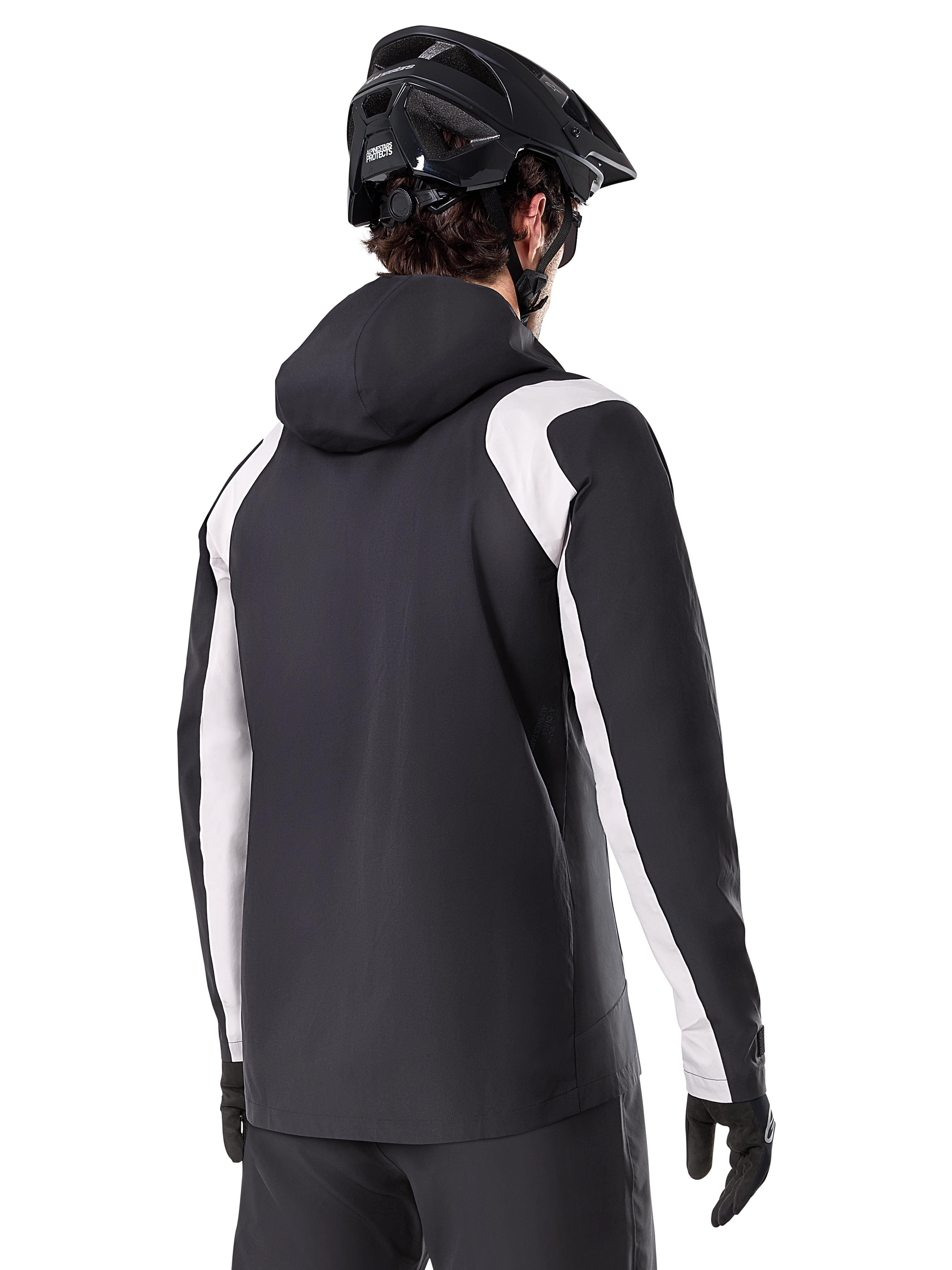 Alpinestars A-Dura Regenjas, mountainbike regenjas, zwart met witte mouwpanelen, achteraanzicht van rijder met een zwarte MTB-helm en handschoenen, technische 2,5-laags waterdichte constructie, mountainbike kleding