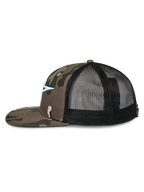 Alpinestars Corp Trucker pet, zijprofiel, groene camouflage twill voorkant en platte klep, zwarte mesh achterkant, wit geborduurd Astars-logo, casual motorsport streetwear
