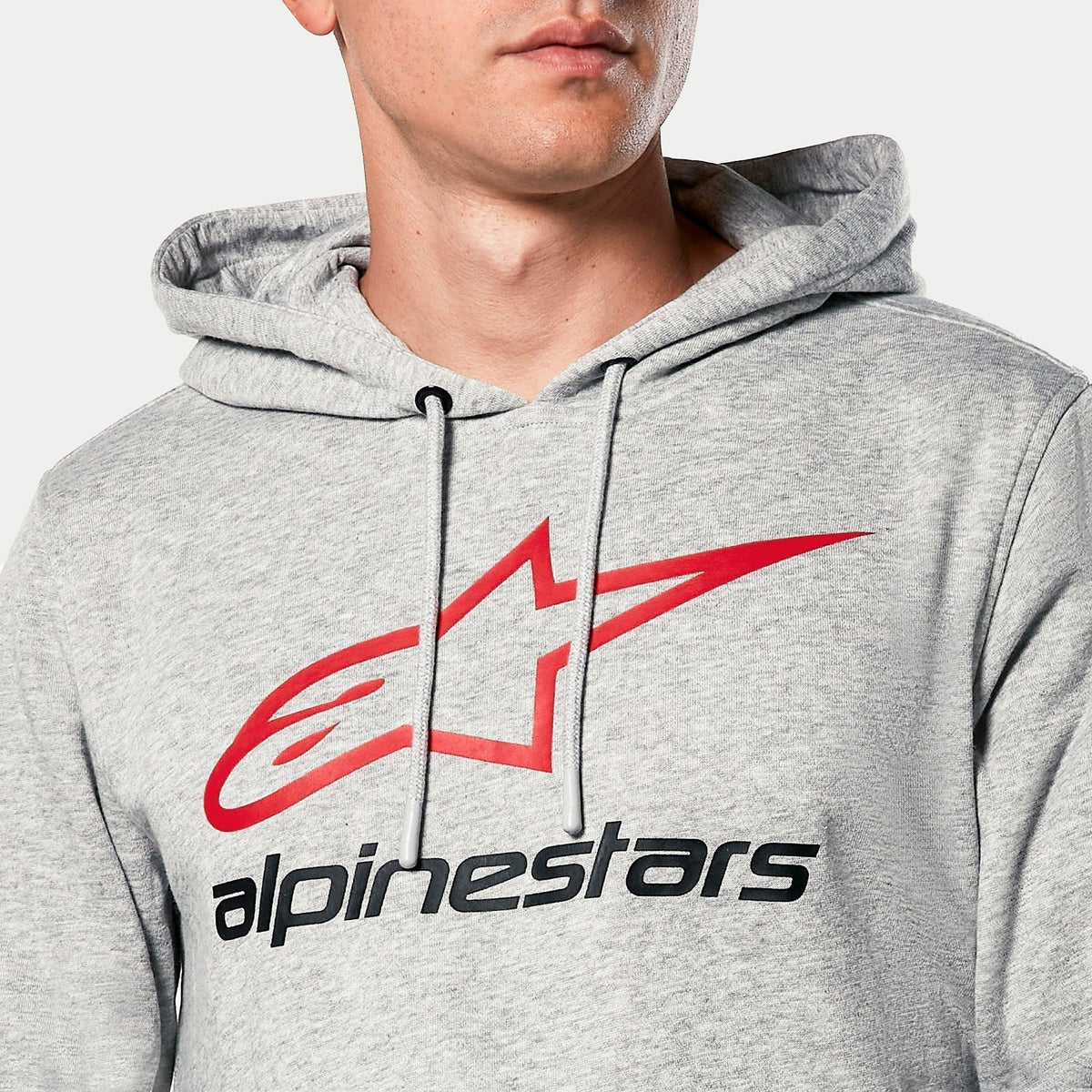 Alpinestars Always V3 Hoodie, grijs gemêleerd, close-up van de borst met rood sterlogo en zwarte Alpinestars-tekst, jersey gevoerde capuchon met grijze trekkoorden, casual motorsport streetwear