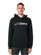 Alpinestars Blaze V3 hoodie, zwart met wit logo, casual streetwear, met kangoeroezak en capuchon met trekkoord, gedragen door een man, modern door de motorsport geïnspireerd ontwerp