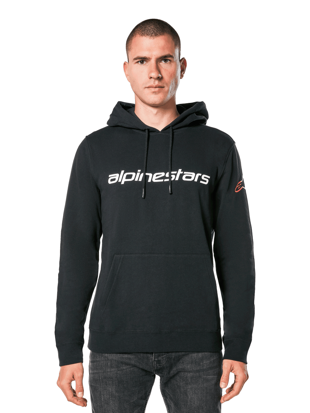 Alpinestars Linear Wordmark V3 hoodie, zwarte pullover hoodie, wit Alpinestars woordmerk op de borst, rood Ageless logo op de mouw, kangoeroezak aan de voorzijde, capuchon met trekkoord, gedragen door een mannelijk model, casual motorsport-geïnspireerde streetwear