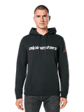 Alpinestars Linear Wordmark V3 hoodie, zwarte pullover hoodie, wit Alpinestars woordmerk op de borst, rood Ageless logo op de mouw, kangoeroezak aan de voorzijde, capuchon met trekkoord, gedragen door een mannelijk model, casual motorsport-geïnspireerde streetwear