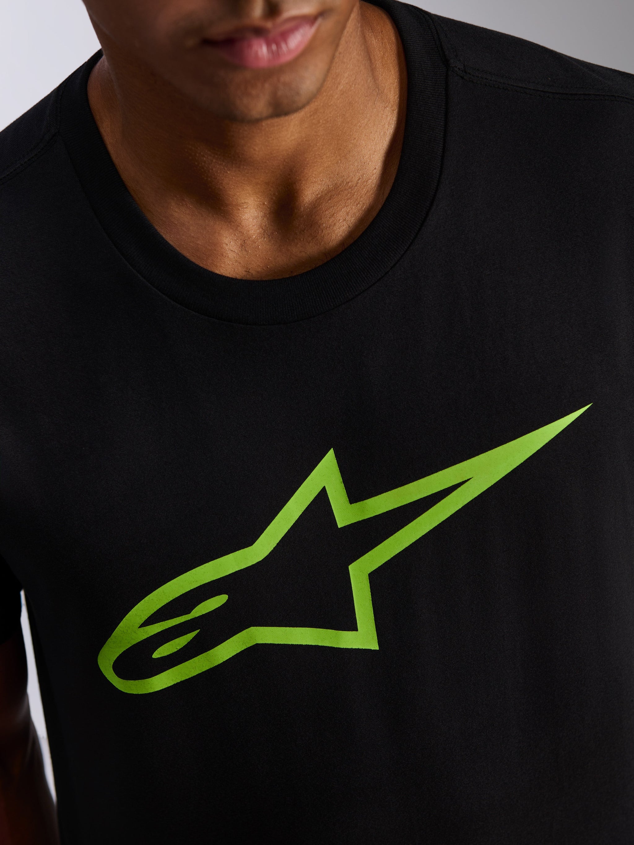 Alpinestars Ageless 2.0 CSF Tee, Short Sleeve T-Shirt, Black with Bright Green Star Logo, close-up of chest graphic and neckline, casual motorsport streetwear