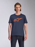 Alpinestars Ageless 2.0 CSF Tee, T-shirt met korte mouwen, marineblauw met oranje logo, MX-helmkunst op de voorzijde, casual motorsport-geïnspireerde streetwear, model draagt het shirt met een donkere jeans
