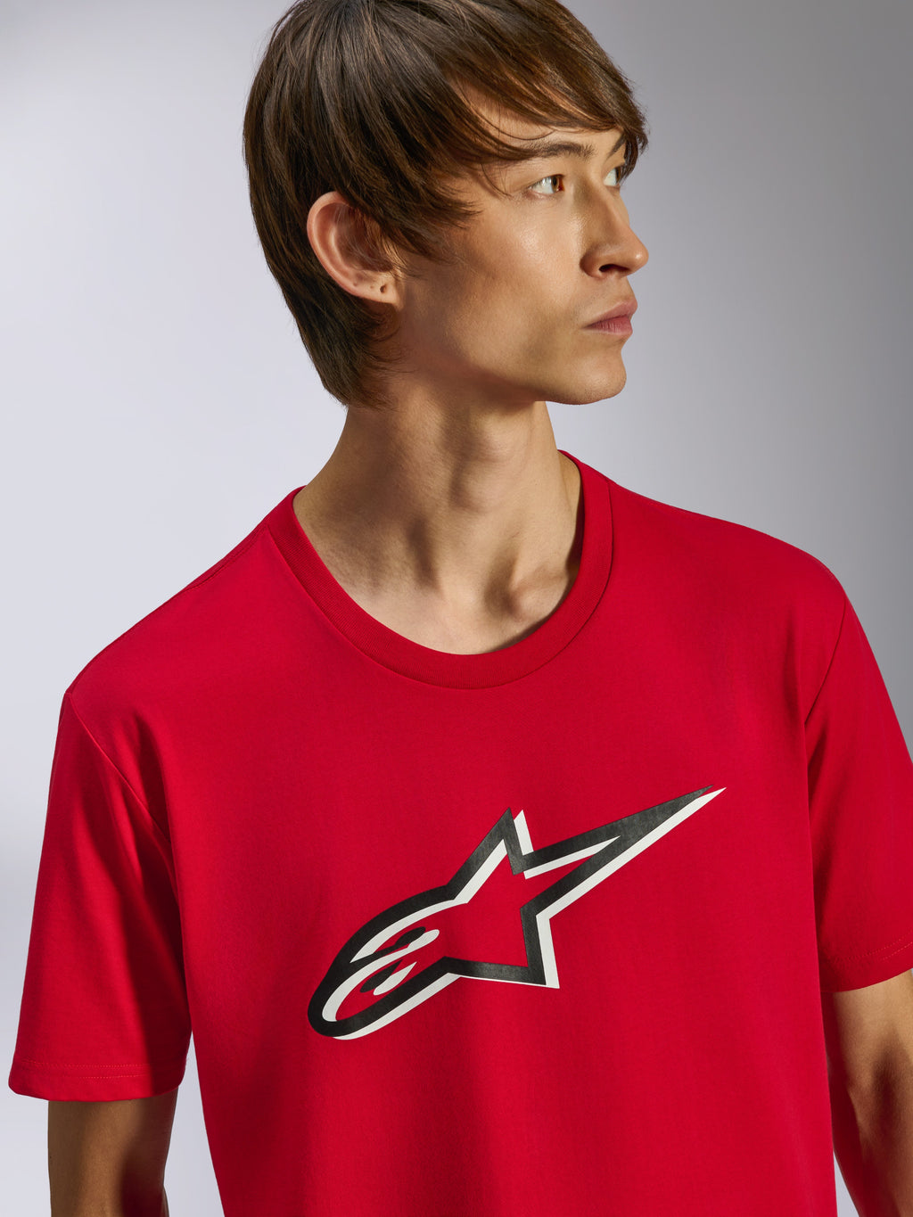 Alpinestars Ageless Shadow CSF Tee, T-shirt met korte mouwen, rood, met Ageless-logo met zwart-wit schaduweffect op de voorzijde, gedragen door model, casual motorsport streetwear