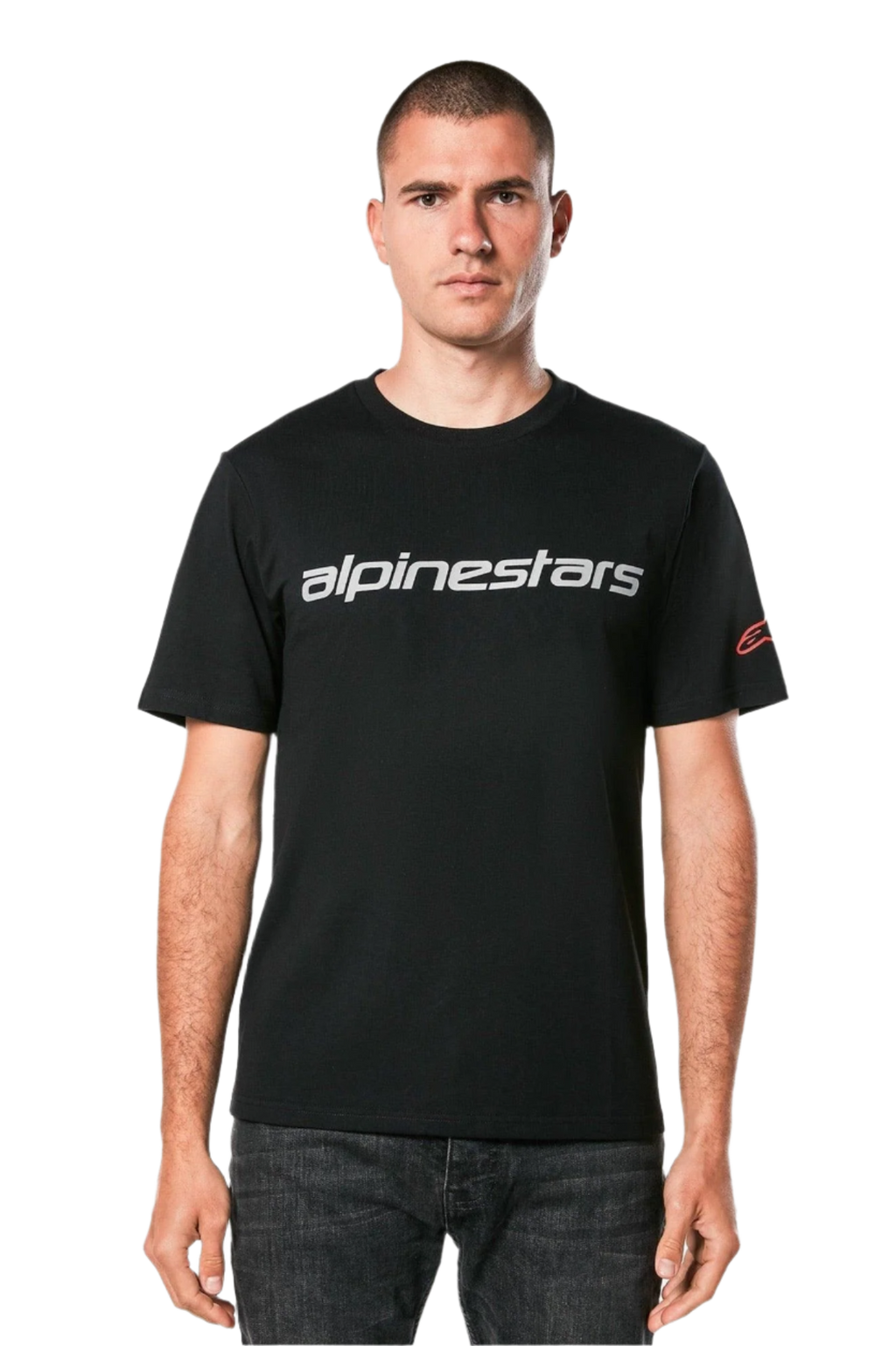 Alpinestars Linear Wordmark 2.0 CSF Tee, t-shirt met korte mouwen, zwart, grijs lineair woordmerk over de borst en rood Ageless-logo op de mouw, gedragen door een model met donkere jeans, casual op motorsport geïnspireerde streetwear