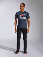 Alpinestars Ride 4.0 CSF Tee, T-shirt met korte mouwen, donkerblauw met rood Alpinestars sterlogo en witte 'RIDE' tekst op de borst, gedragen door model met zwarte broek en zwarte sneakers, casual op motorsport geïnspireerde streetwear