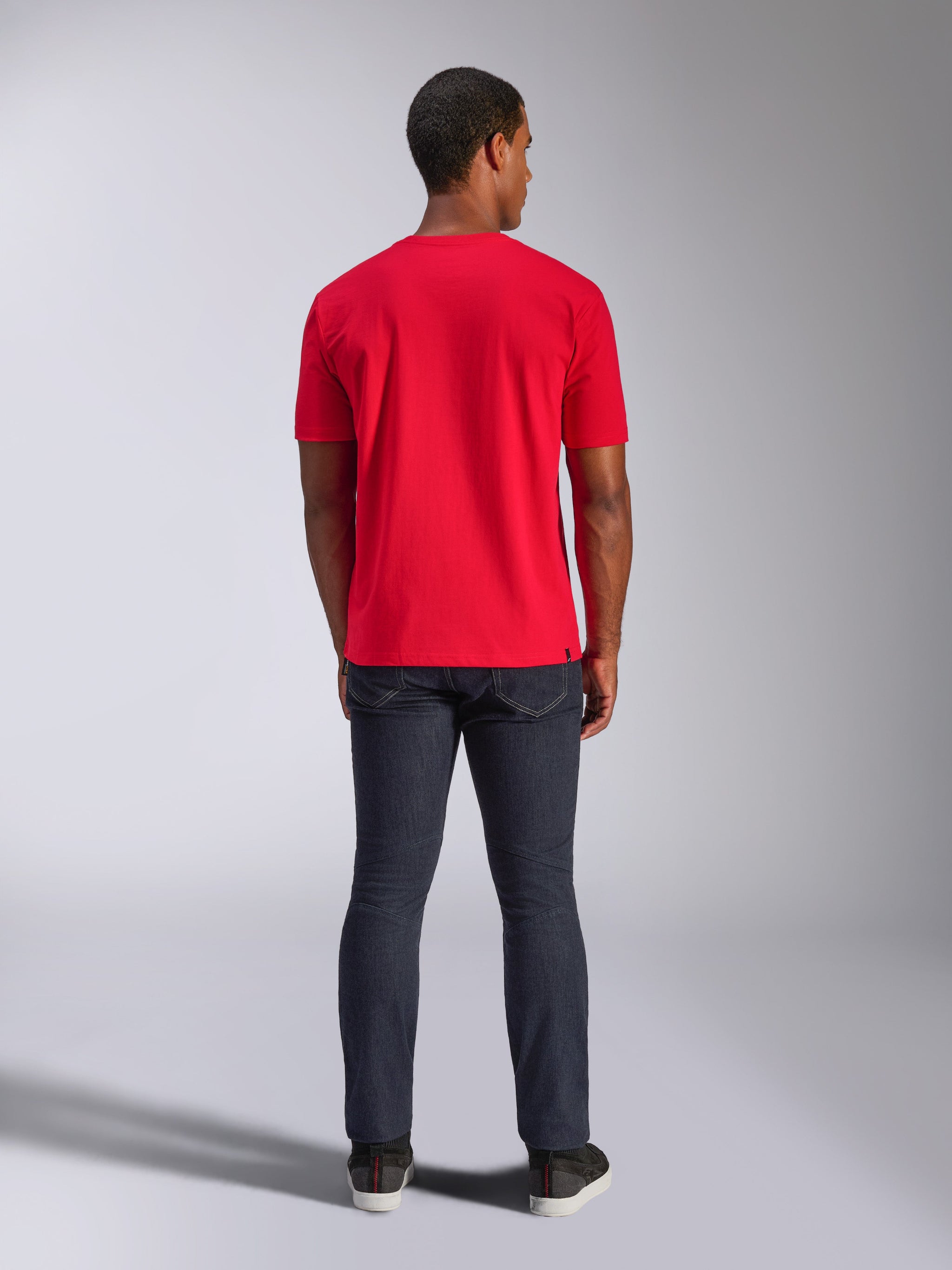 Alpinestars CSF Tee, T-shirt met korte mouwen, rood, achteraanzicht op model, gecombineerd met een donkere denim jeans, casual op motorsport geïnspireerde streetwear