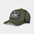 Alpinestars Heritage Patch Trucker pet, militair zwart en olijfgroen, gebogen klep met gestructureerde kroon, grote geborduurde patch op de voorzijde met een vintage motorwiel-graphic en 'Racing Ahead' tekst, zwarte mesh achterkant met wit Ageless-logo aan de zijkant.