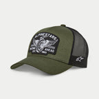Alpinestars Heritage Patch Trucker pet, militair zwart en olijfgroen, gebogen klep met gestructureerde kroon, grote geborduurde patch op de voorzijde met een vintage motorwiel-graphic en 'Racing Ahead' tekst, zwarte mesh achterkant met wit Ageless-logo aan de zijkant.