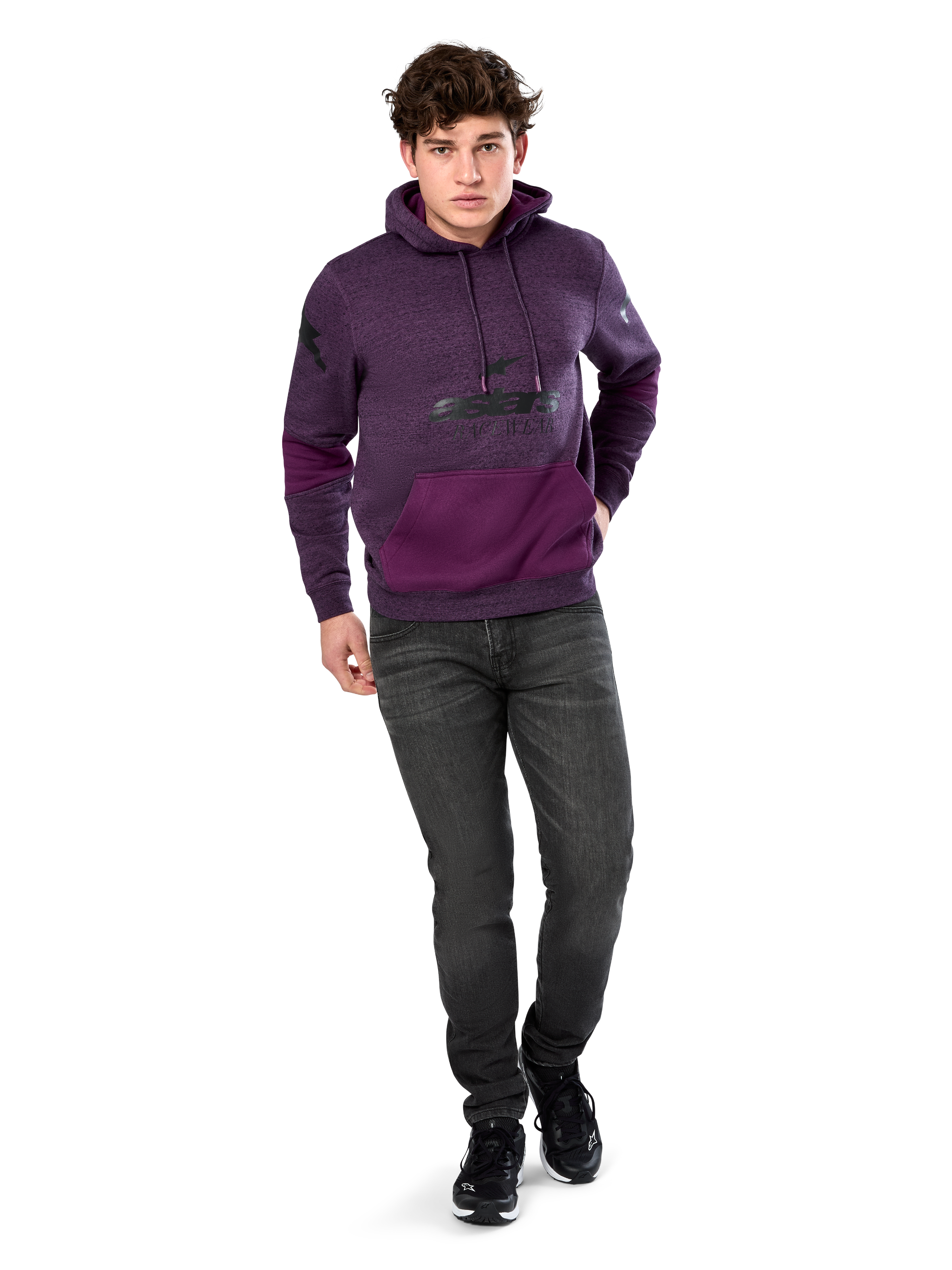 Alpinestars Perpetuate Hoodie, casual streetwear, paars gemêleerd fleece met donkerpaarse kleurvlakken op de kangoeroezak en mouwen, zwart logo op de borst, capuchon met trekkoord, gedragen door model met donkergrijze jeans en zwarte sneakers