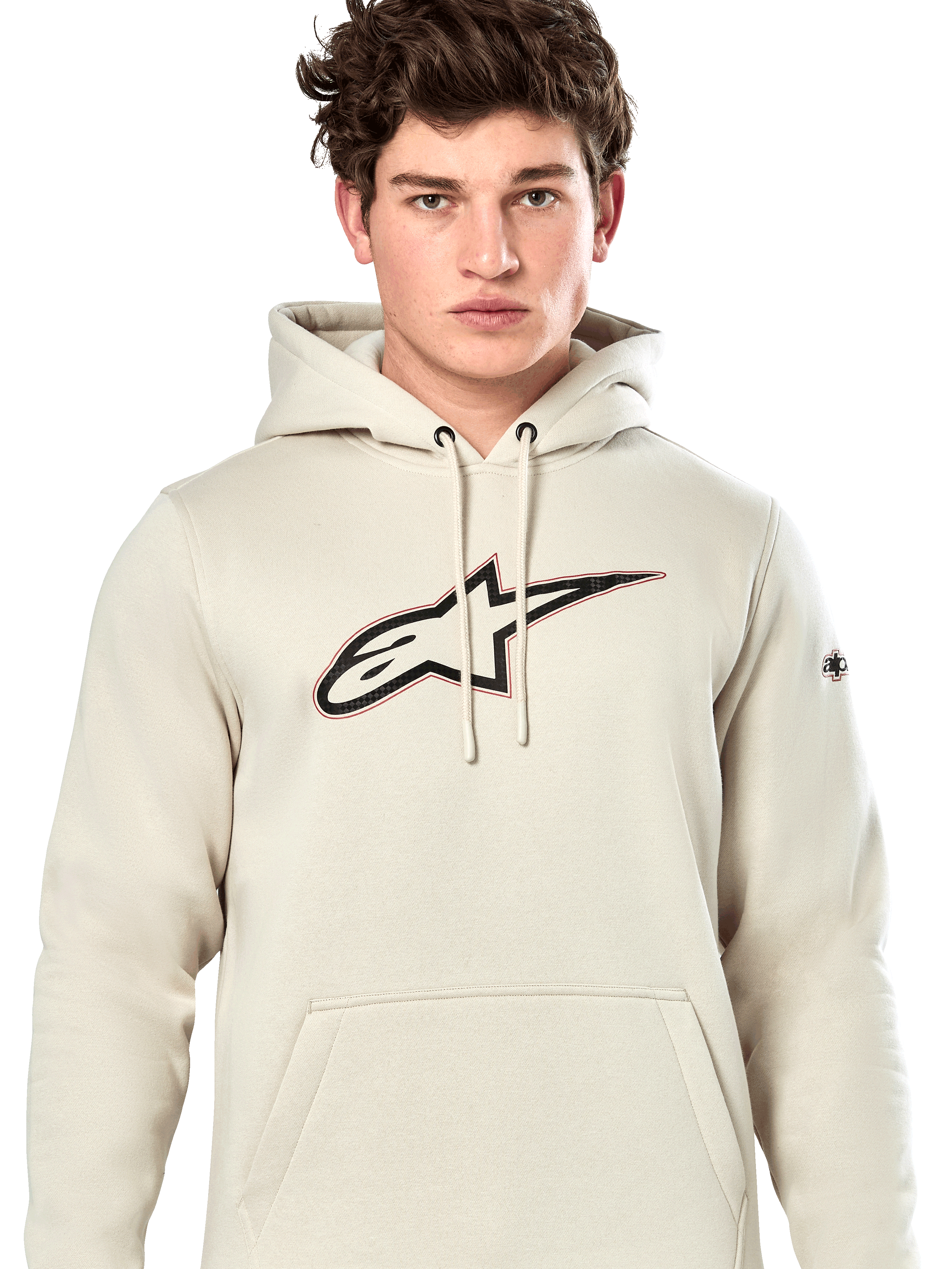 Alpinestars Insignia Hoodie, casual pullover sweatshirt, Off White met logo met carbonvezel-look op de borst, rode omtrek, capuchon met trekkoord en kangoeroezak, gedragen door model, op de motorsport geïnspireerd ontwerp