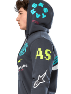 Alpinestars Variegate Hoodie, gunmetal grijze fleece hoodie met ritssluiting, zijprofiel van model, multi-logo artwork in neongeel, lichtblauw en wit, met 'AS' branding op de mouw en 'STARS' op de capuchon, casual op motorsport geïnspireerde streetwear