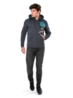 Alpinestars Variegate Hoodie, fleece hoodie met ritssluiting, Gunmetal grijs, gedragen door een model met zwarte jeans en sneakers, voorzien van teal 'ASTARS' branding en kleurrijke logo-art op de mouwen en borst, casual op de motorsport geïnspireerde streetwear