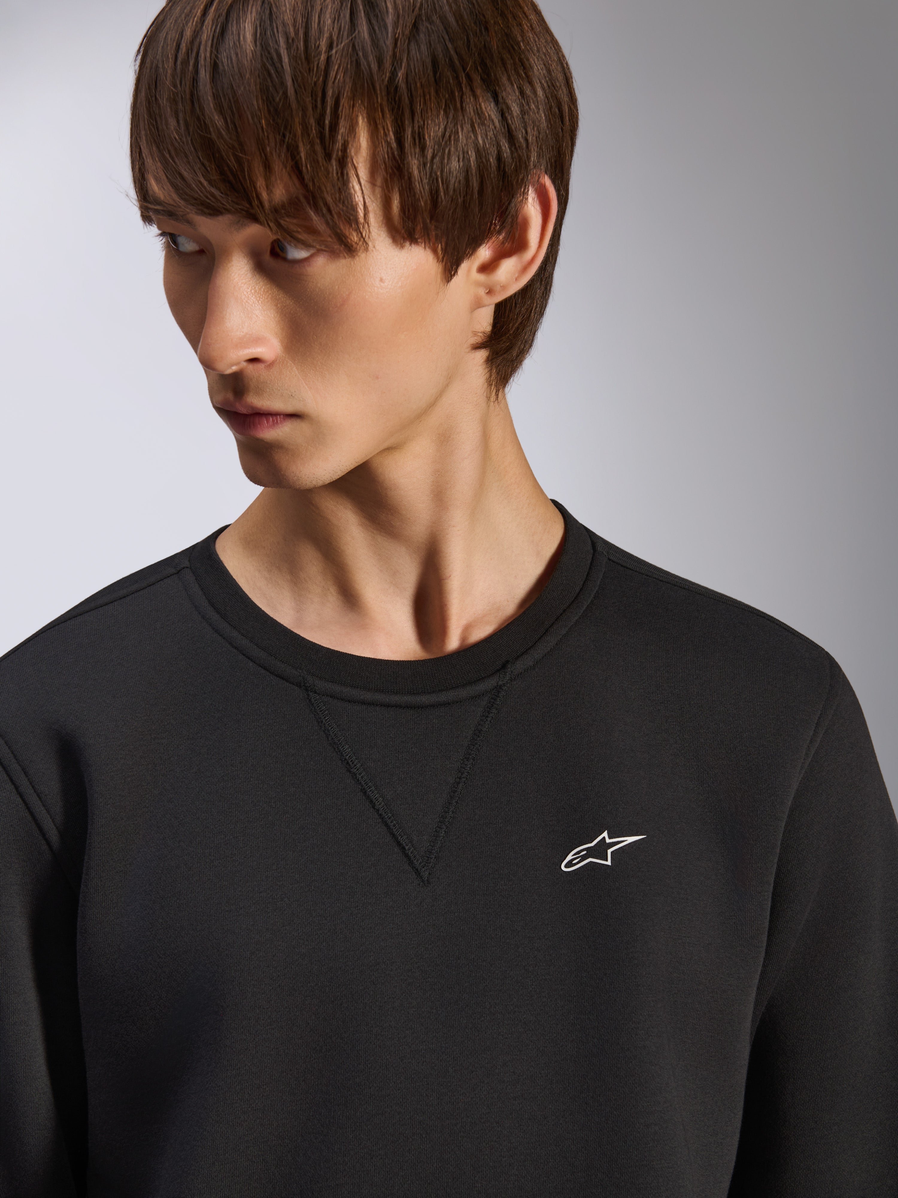 Alpinestars Positive Crew sweatshirt, zwarte crewneck met V-stiksel detail bij de hals, klein wit Alpinestars-logo op de linkerborst, casual op motorsport geïnspireerde streetwear