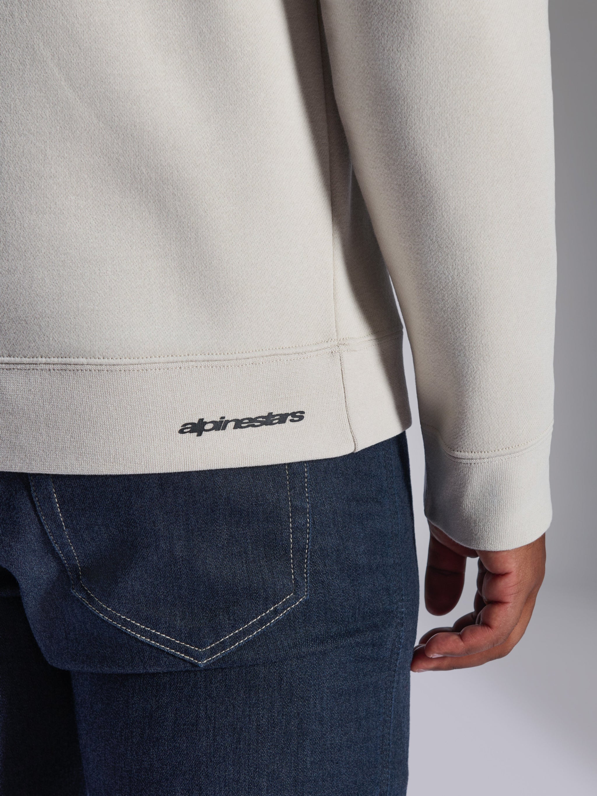 Alpinestars Positive Crew Sweatshirt, Off White, detailopname van de geribbelde zoom en manchet, klein zwart Alpinestars-logo, casual motorsport-geïnspireerde kleding
