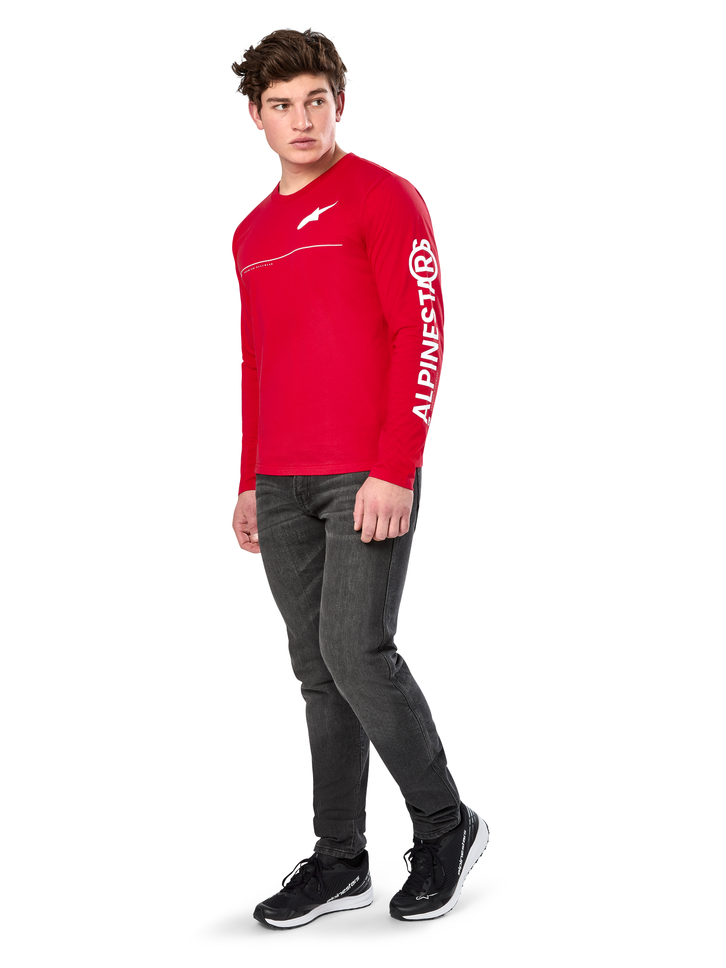 Alpinestars Committed CSF Tee, T-shirt met lange mouwen, rood, met wit Astars-logo op de borst en Alpinestars-branding op de mouw, gedragen door een model met donkere jeans en zwarte sneakers, casual motorsport streetwear
