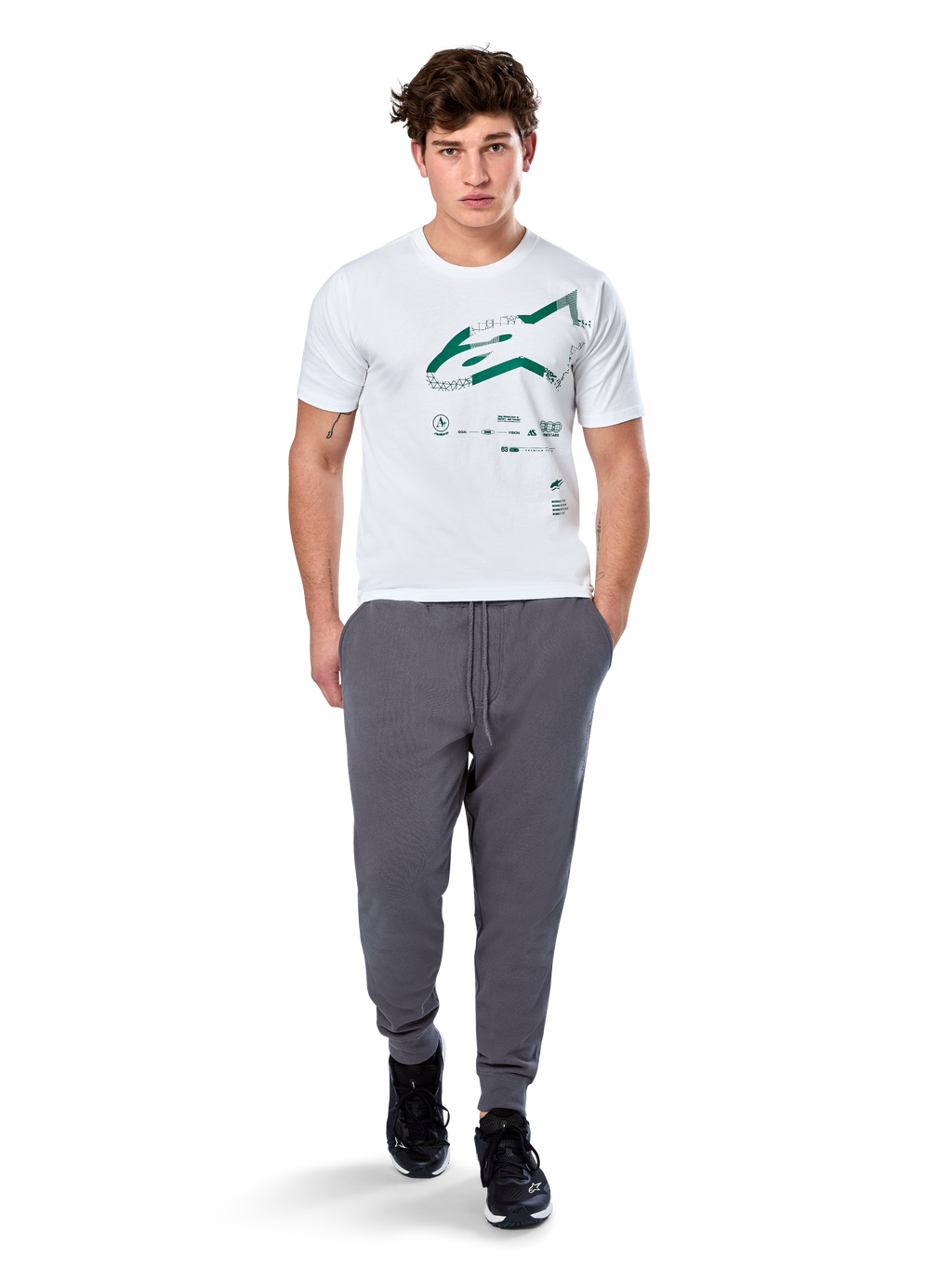 Alpinestars Geografica CSF Tee, T-shirt met korte mouwen, wit, groen Astars-logo met geografische multi-tech graphic, gedragen met grijze joggingbroek en zwarte sneakers, casual motorsport streetwear