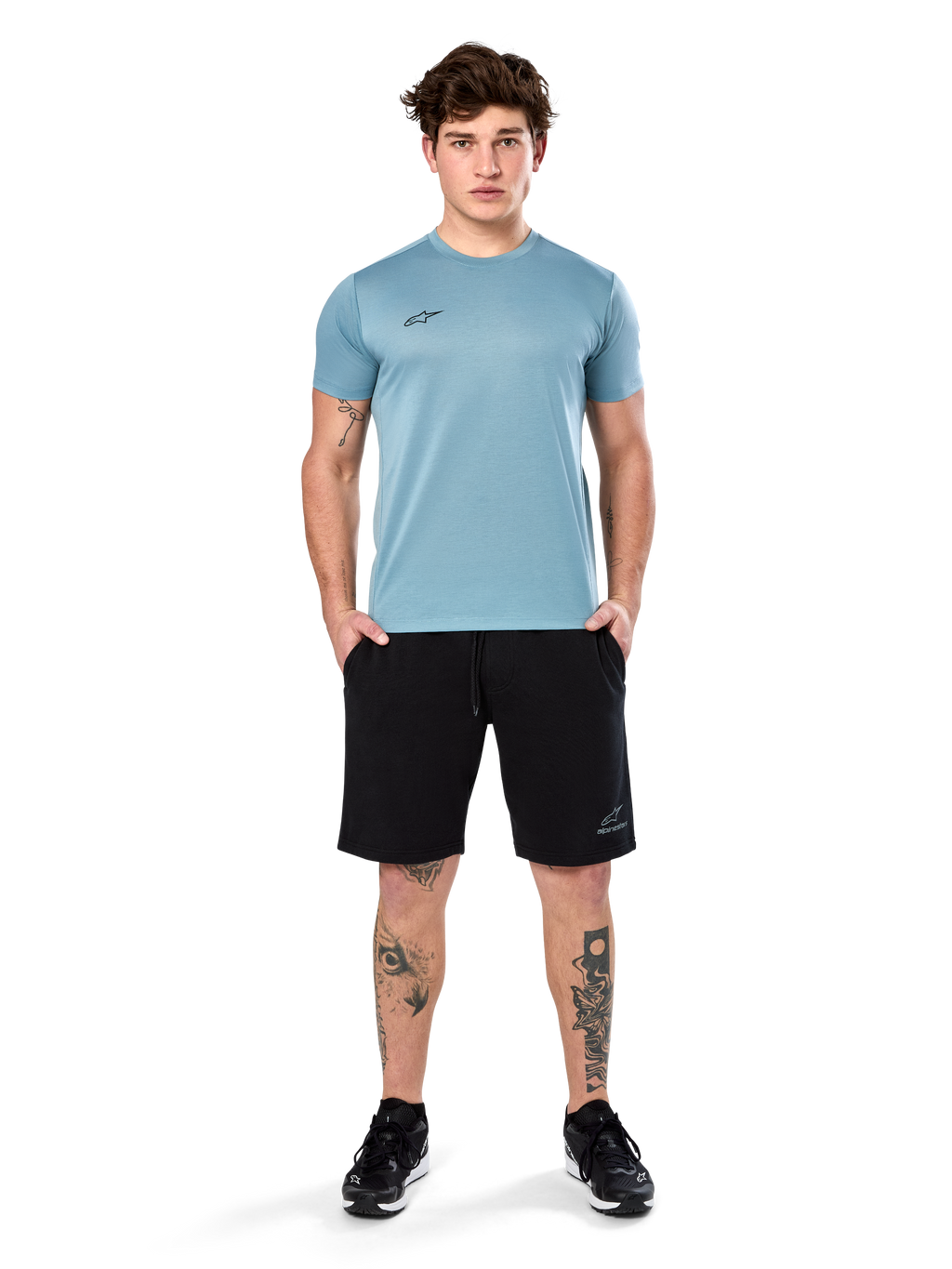 Alpinestars Point Performance Tee, T-shirt met korte mouwen, Ice Blue, met een klein zwart logo op de voorkant, ronde hals, gedragen door een model met zwarte shorts en zwarte sneakers, casual vochtafvoerende sportkleding