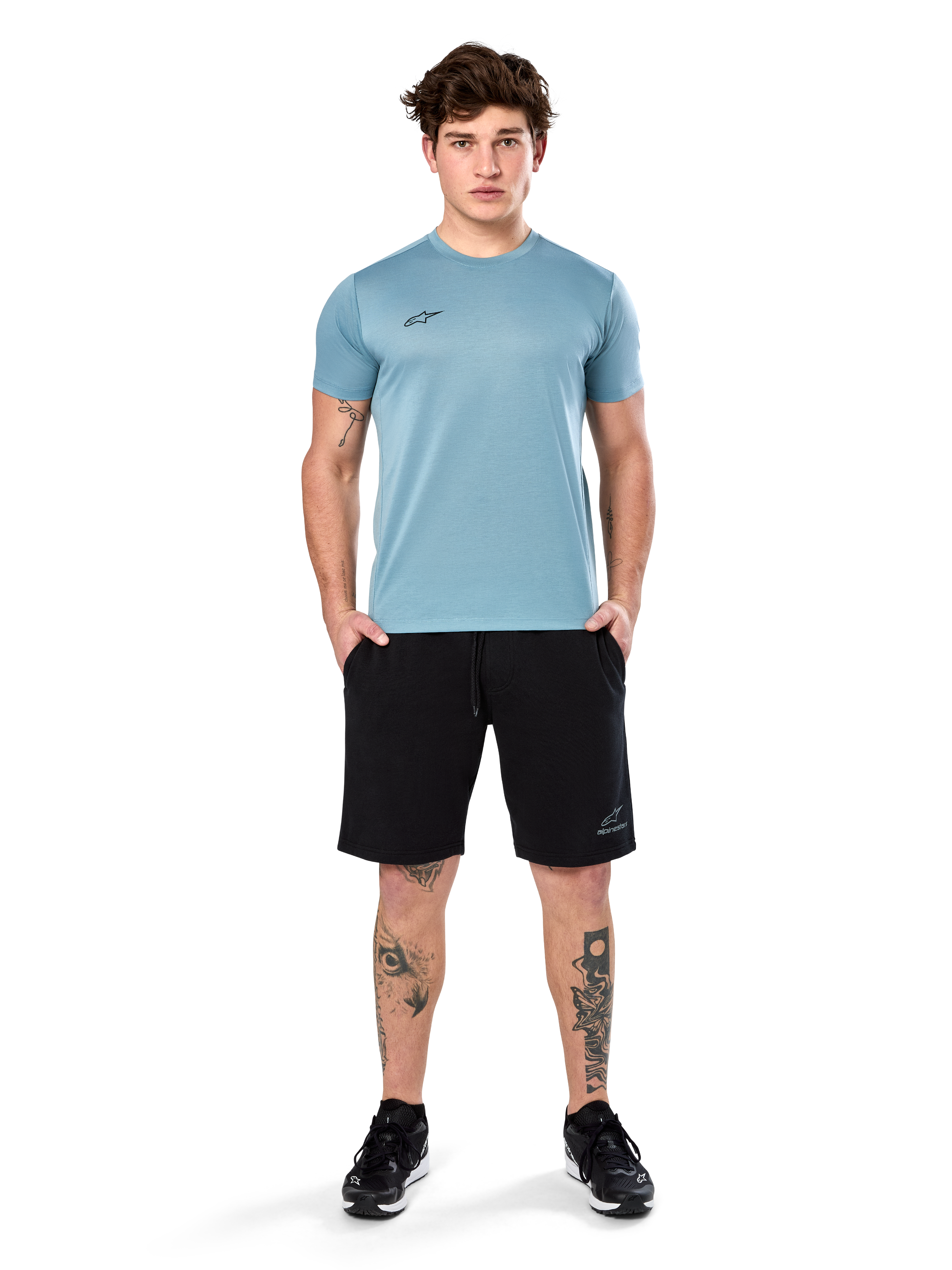 Alpinestars Point Performance Tee, T-shirt met korte mouwen, Ice Blue, met een klein zwart logo op de voorkant, ronde hals, gedragen door een model met zwarte shorts en zwarte sneakers, casual vochtafvoerende sportkleding