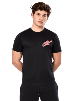 Alpinestars Attrition Performance Tee, T-shirt met korte mouwen, zwart met roze Astars-logo op de borst, gedragen door mannelijk model, casual motorsport performance kleding