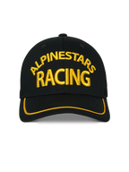 Alpinestars Luminary pet, zwarte snapback cap, geel 3D Alpinestars Racing borduursel aan de voorzijde, gebogen klep met gele sutache-rand, casual motorsport hoofdbedekking