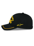 Alpinestars Luminary pet, zwarte snapback cap zijaanzicht, geel 3D-borduurwerk op de voor- en zijkant, gebogen klep met gele sutache rand, gestructureerde katoenen keperstof constructie