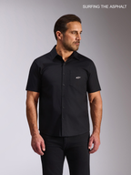 Alpinestars Strive Woven Shirt, short-sleeve button-front casual shirt worn by a male model, black stretch poplin, featuring a chest pocket with a white Alpinestars logo