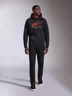 Alpinestars Pulse Hoodie, black casual streetwear hoodie, red and gray Astars combo logo with speed line fade on chest, drawstring hood, front pouch pocket, long sleeves, paired with black pants and sneakers, motorsport-inspired design