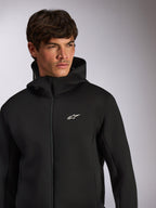 Alpinestars Cypher Hoodie, casual sportkleding, zwarte hoodie met rits en wit Astars-logo op de borst, hoge capuchon, gedragen door een mannelijk model