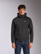 Alpinestars Cypher Hoodie, zwarte fleece hoodie met ritssluiting aan de voorzijde, voorzien van een hoge capuchon met witte branding en een klein wit Astars-logo op de borst, gedragen door een model met blauwe jeans, casual op motorsport geïnspireerde streetwear.