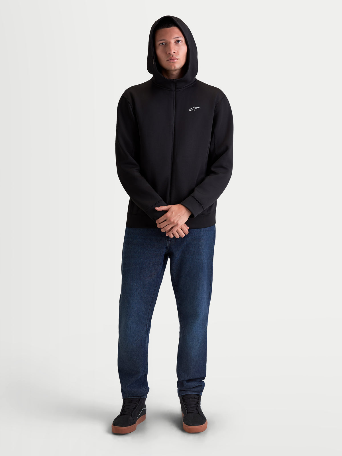 Alpinestars Cypher hoodie, heren-sportswear hoodie met rits, zwart, tri-blend dubbele fleece met een hoge capuchon met mesh-voering en een klein wit Astars-logo op de borst, gedragen door een model voor casual kleding.