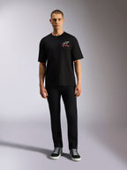 Alpinestars Overhang Oversized CSF Tee, Short Sleeve T-Shirt, Black, White Astars Logo with Red Text, worn by a model with black pants and sneakers, casual motorsport streetwear