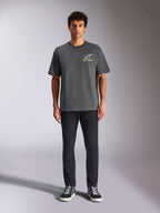 Alpinestars Overhang Oversized CSF Tee, Short Sleeve T-Shirt, Charcoal Gray, featuring a front white and lime green Alpinestars logo, worn by a model with black pants and sneakers, relaxed casual streetwear