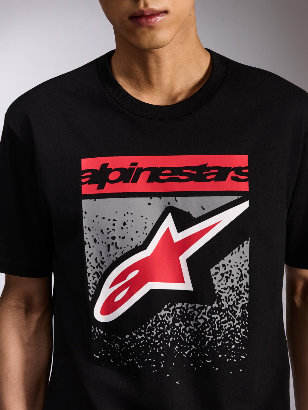 Alpinestars Noka CSF Tee, T-shirt met korte mouwen, zwart, grafische print op de voorzijde met rood Alpinestars-woordmerk en rood-wit Astars-logo op een grijs MX-verloop, casual motorsport streetwear
