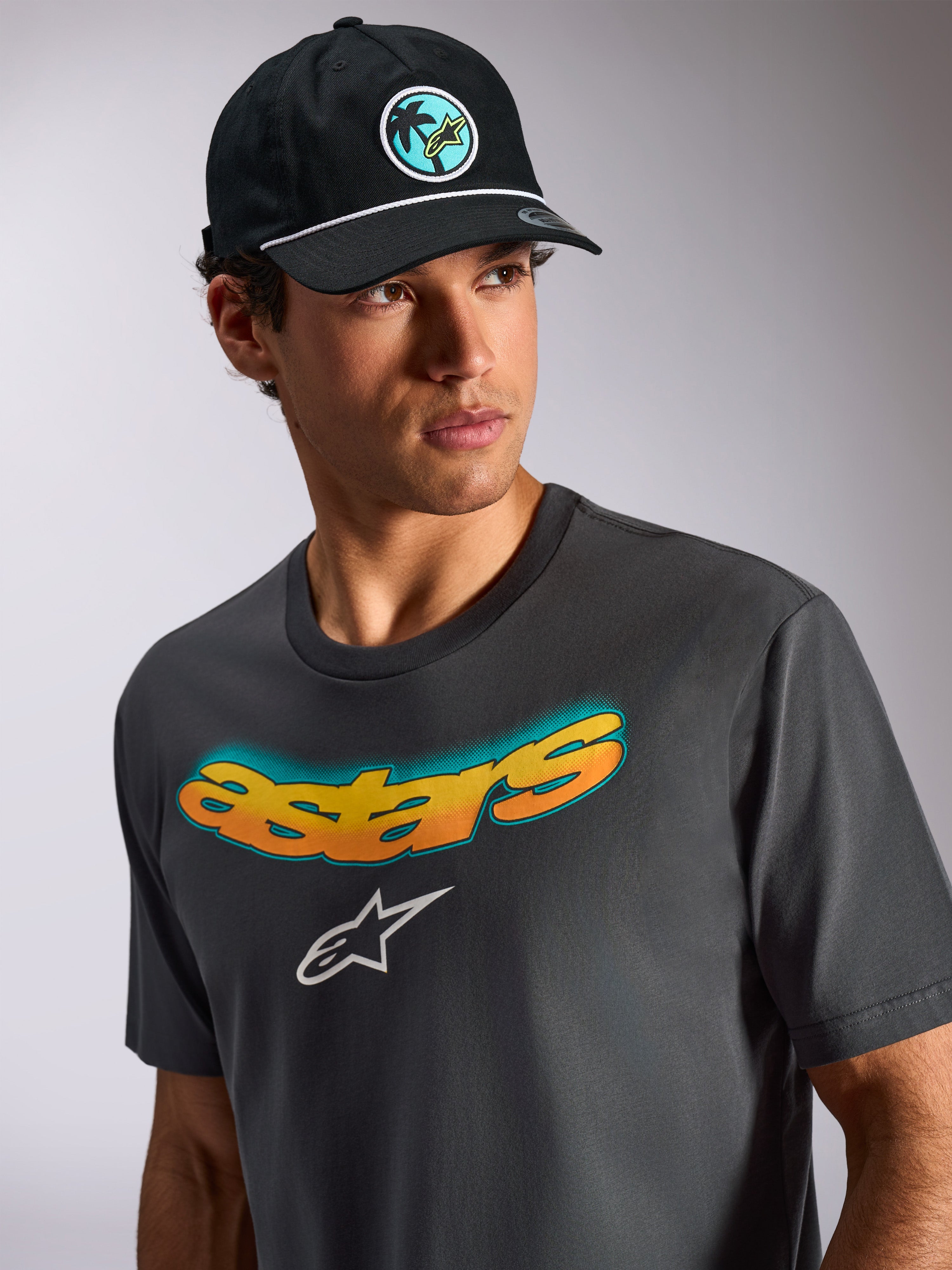 Alpinestars Ellipsoid CSF Tee, T-shirt met korte mouwen, houtskoolgrijs, gebogen Astars-tekst met geel en oranje kleurverloop, wit Astars-logo, casual motorsport streetwear lifestyle