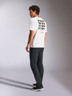 Alpinestars Pop Helmet CSF Tee, wit T-shirt met korte mouwen, achteraanzicht op model met kleurrijke M10 helm graphics, gestyled met een donkere broek en zwarte sneakers, casual motorsport-geïnspireerde streetwear