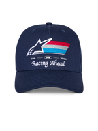 Alpinestars Trifecta Snapback Hat, Navy Blue cap with curved bill, featuring embroidered front logo with white star and tri-color stripes, 'Racing Ahead' and 'Goal One Vision' white text, structured crown, casual motorsport-inspired headwear