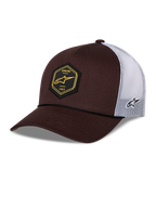 Alpinestars Hexeon Trucker pet, bruin en wit, gebogen klep met gestructureerde donkerbruine voorkant en witte mesh achterkant, voorzien van een zwarte zeshoekige patch op de voorkant met geel logo, geborduurd logo aan de zijkant en klassieke trucker-stijl.