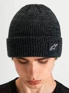 Alpinestars Unload Rib Cuff muts, sportswear gebreide wintermuts, donkergrijs melange, voorzien van een omslag en geweven Alpinestars logo-patch, close-up productweergave op model