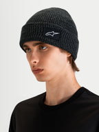 Alpinestars Unload Rib Cuff muts, sportswear gebreide muts in donkergrijs melange, gedragen door een model met de ondiepe pasvorm en SAstars geweven patchlogo zichtbaar