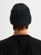Alpinestars Unload Rib Cuff muts, sportswear wintermuts in charcoal melange, achteraanzicht op model met gebreide jerseysteekconstructie en opgezette omslag