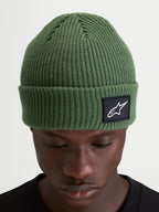 Alpinestars Unload Rib Cuff muts, gebreide sportmuts in groen met geribbeld ontwerp en geweven Alpinestars patch op de omslag gedragen door een model