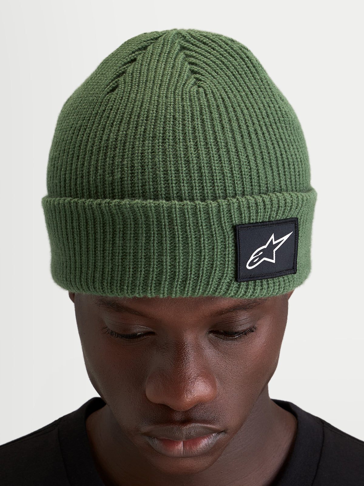 Alpinestars Unload Rib Cuff muts, gebreide sportmuts in groen met geribbeld ontwerp en geweven Alpinestars patch op de omslag gedragen door een model