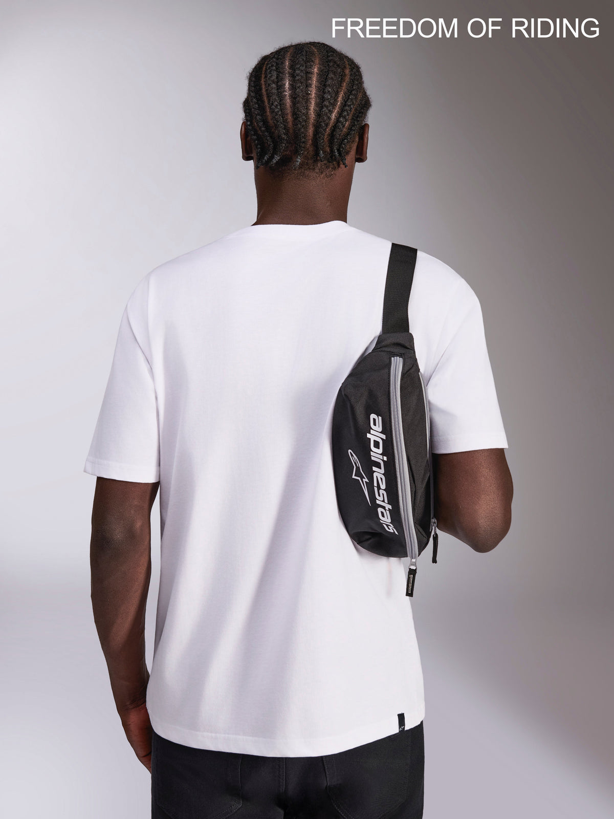 Alpinestars Only Linear heuptas, urban sportswear heuptas, zwart en wit, 2L inhoud, 100% polyester met Alpinestars-logo, gedragen als crossbody-tas door een model voor dagelijks gebruik.