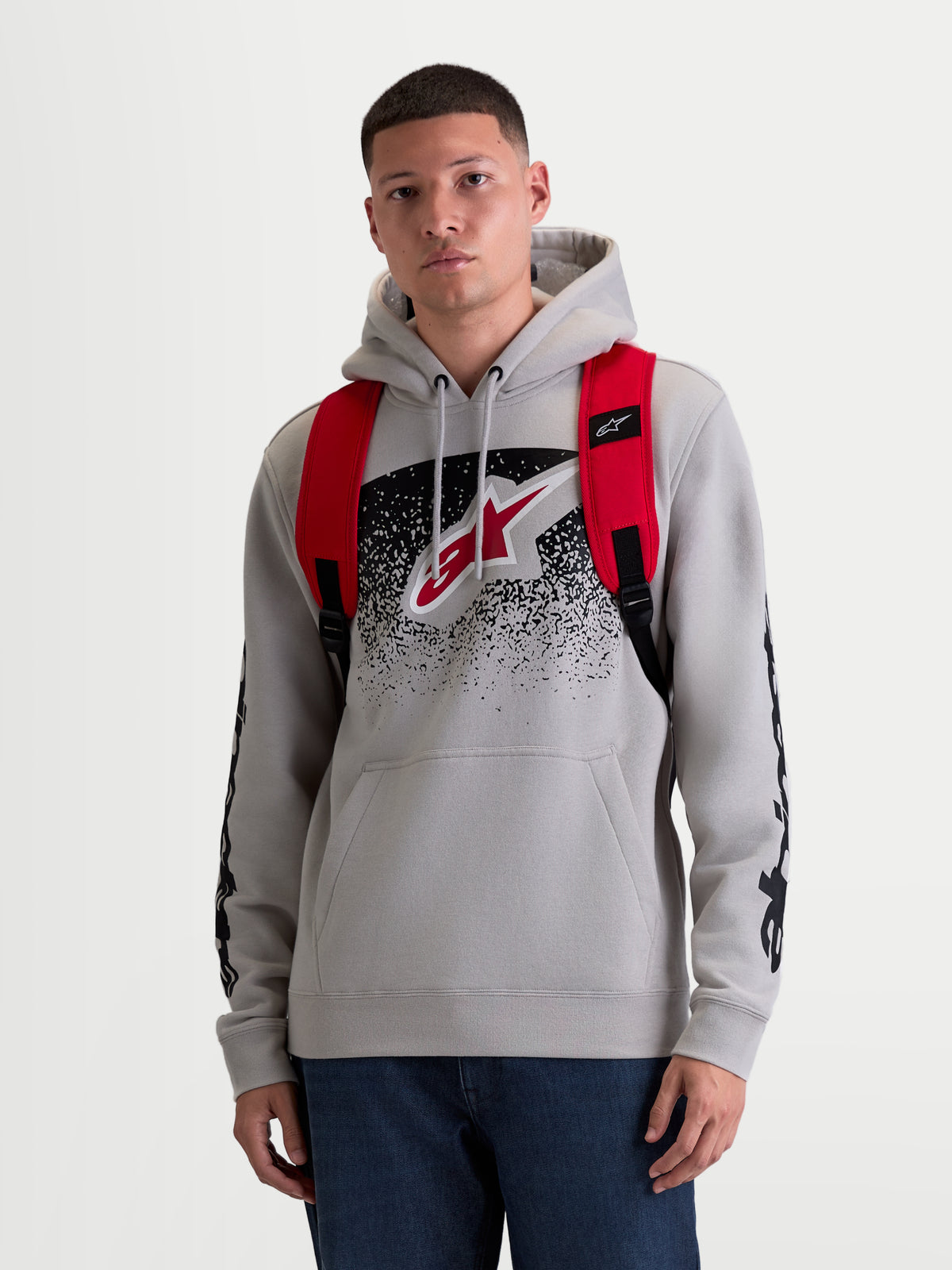 Alpinestars GFX Boss rugzak, 20L urban sportswear dagrugzak voor heren en dames, rood en zwart, duurzaam 600D polyester, vooraanzicht op model met verstelbare air-mesh schouderbanden en verhoogde siliconen branding.