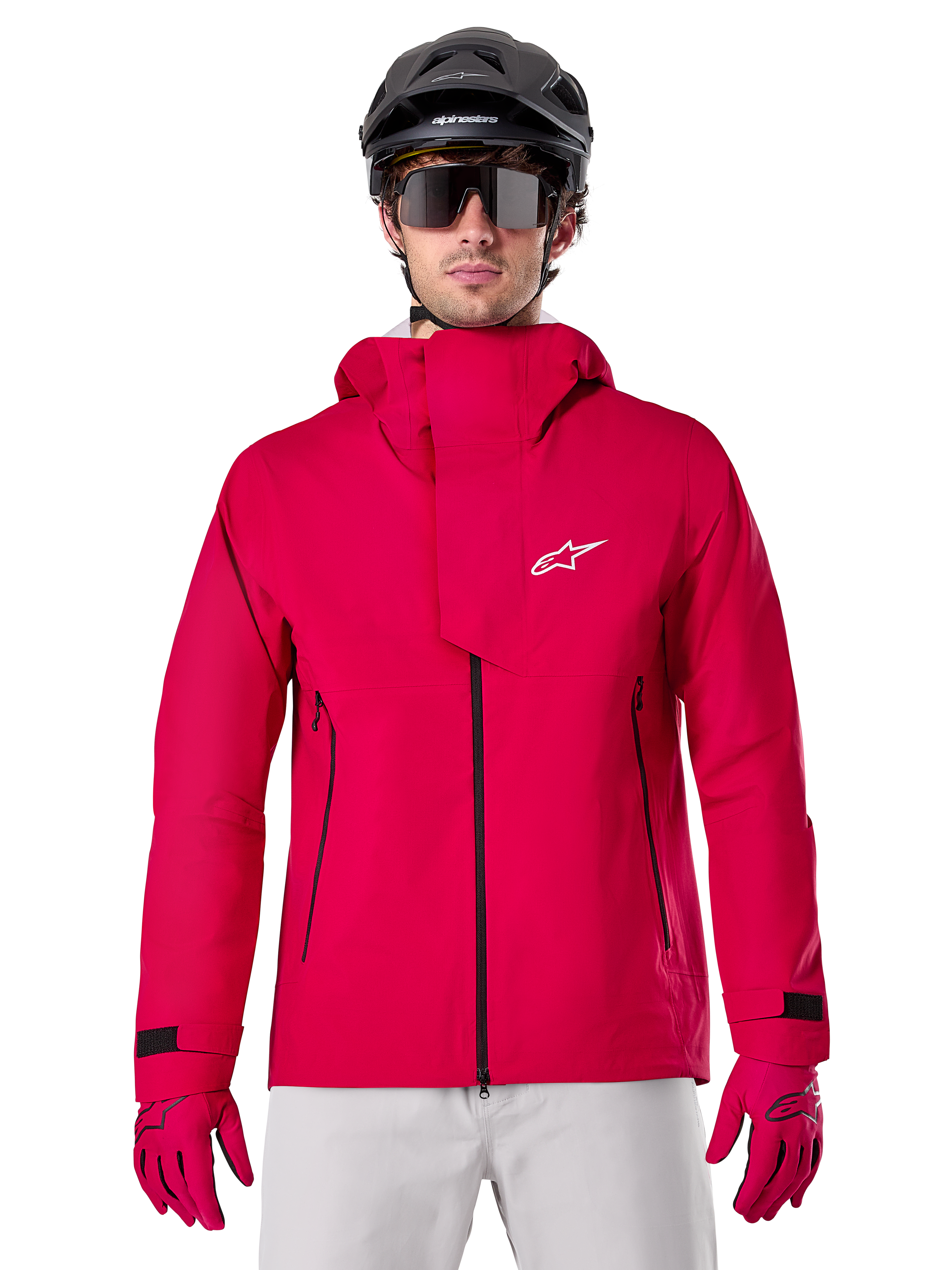 Alpinestars A-Dura Elite Waterproof Jacket, Mountain Bike Rain Jacket, Red Fluo, high collar with white Alpinestars logo, black zipper details, worn with matching gloves and black cycling helmet, technical waterproof cycling gear