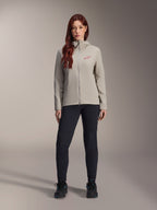 Alpinestars Stella A-Dura Thermal Jacket voor dames, mountainbikejas, titaniumgrijs, gedragen met een zwarte technische broek en zwarte schoenen, voorzien van een met fleece gevoerde capuchon en een rood logo op de borst, ontworpen voor ritten in koud weer
